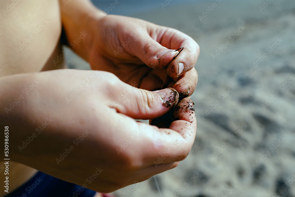 fishing skills concept. a fisherman puts a worm on a hook close-up fishing skills concept. a fisherman puts a worm on a hook close-up