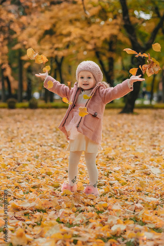 little girl playing in autumn park