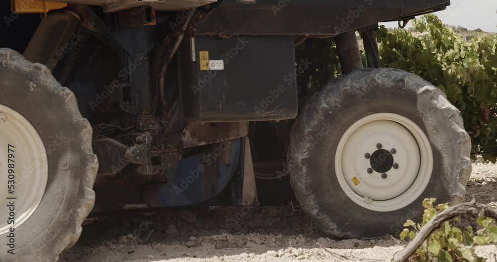 Side Shot of a Blue Grape Harvester Shaking Vineyards from Left to Right in Spain in Slow Motion - 60fps Side Shot of a Blue Grape Harvester Shaking Vineyards from Left to Right in Spain in Slow Motion - 60fps