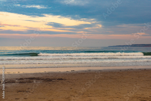 Colorful sunset in the evening by the North Sea with a gloomy sky.