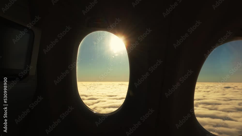 Passengers window view from aircraft during climb with beautiful clouds and the sun shining trough, handheld shot Passengers window view from aircraft during climb with beautiful clouds and the sun shining trough, handheld shot