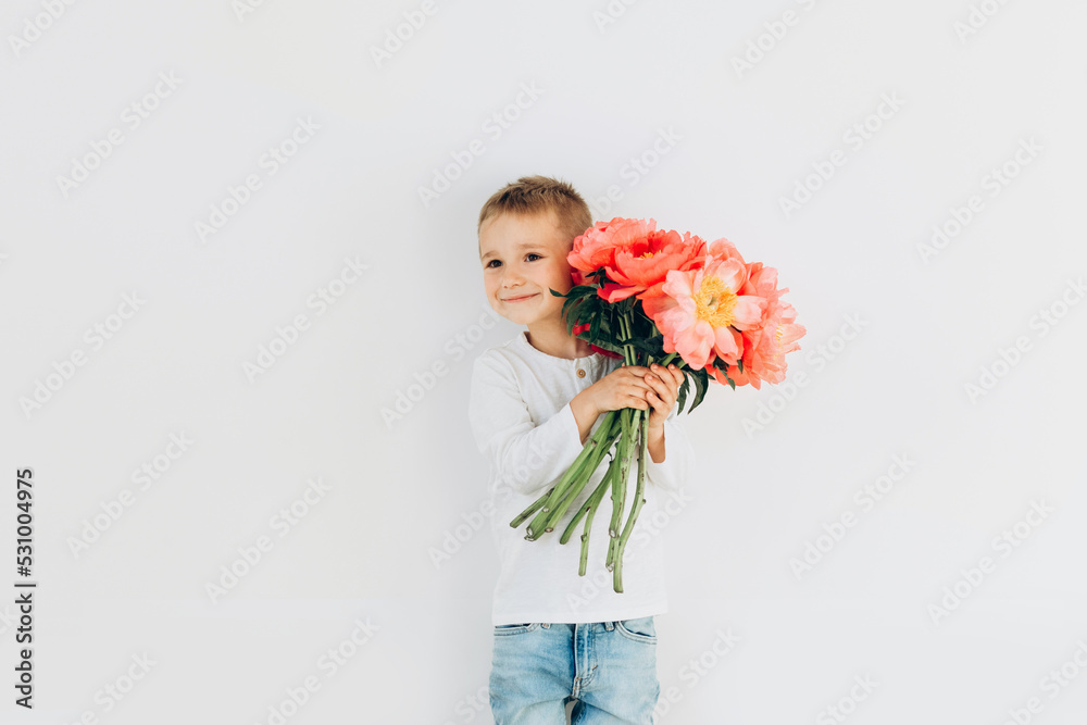 Smily boy with a bouquet of beautiful peonies on a white background Smily boy with a bouquet of beautiful peonies on a white background