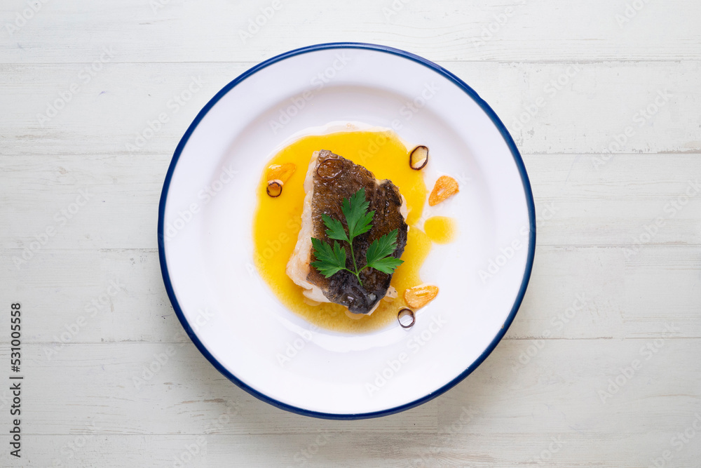 Bacalao al pil pil traditional tapa from the north of Spain. Coconut fish cooked with a delicious sauce made with oil, cod and garlic. Bacalao al pil pil traditional tapa from the north of Spain. Coconut fish cooked with a delicious sauce made with oil, cod and garlic.