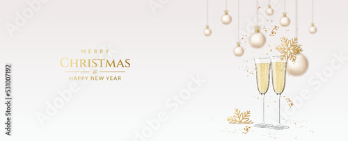 Christmas and New Year greeting card with wineglasses with champagne, snowflakes and christmas balls.	