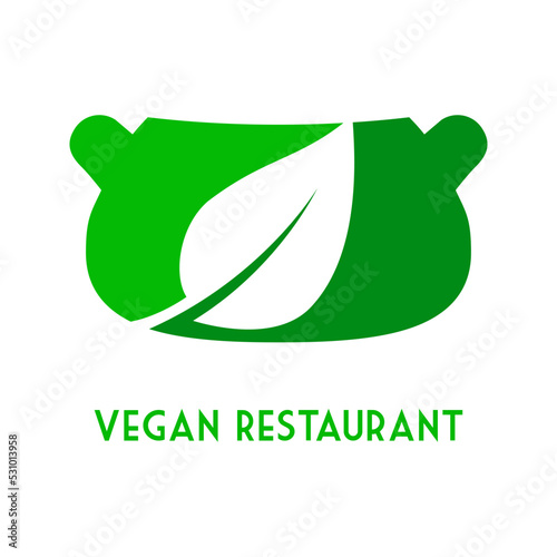 Concepto dieta vegana verde. Logo con texto Vegan Restaurant con silueta de cazuela y hoja de planta en espacio negativo