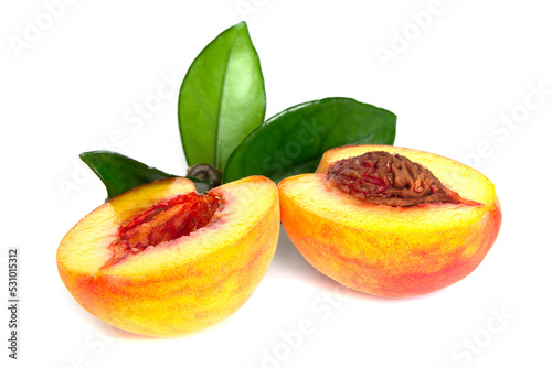 Peach sliced into two halves with leaf on white background isolated close up