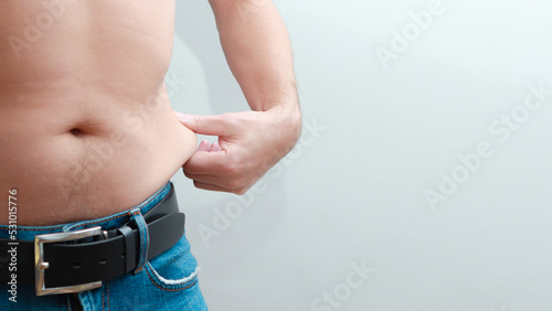 Foto Man holding his excess fat around his waist