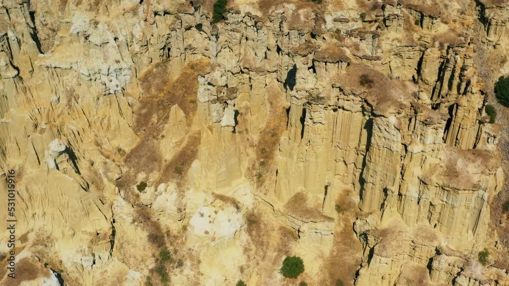 aerial footage of fairy chimneys, kuladokya made by volcanic mountains and wind in million years rock formations iconic and touristic attraction point with blue sky and clouds roads and visitors