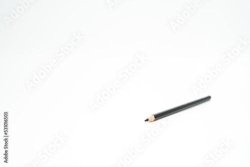 black wooden colored pencil on a white background with a point (lead) in focus