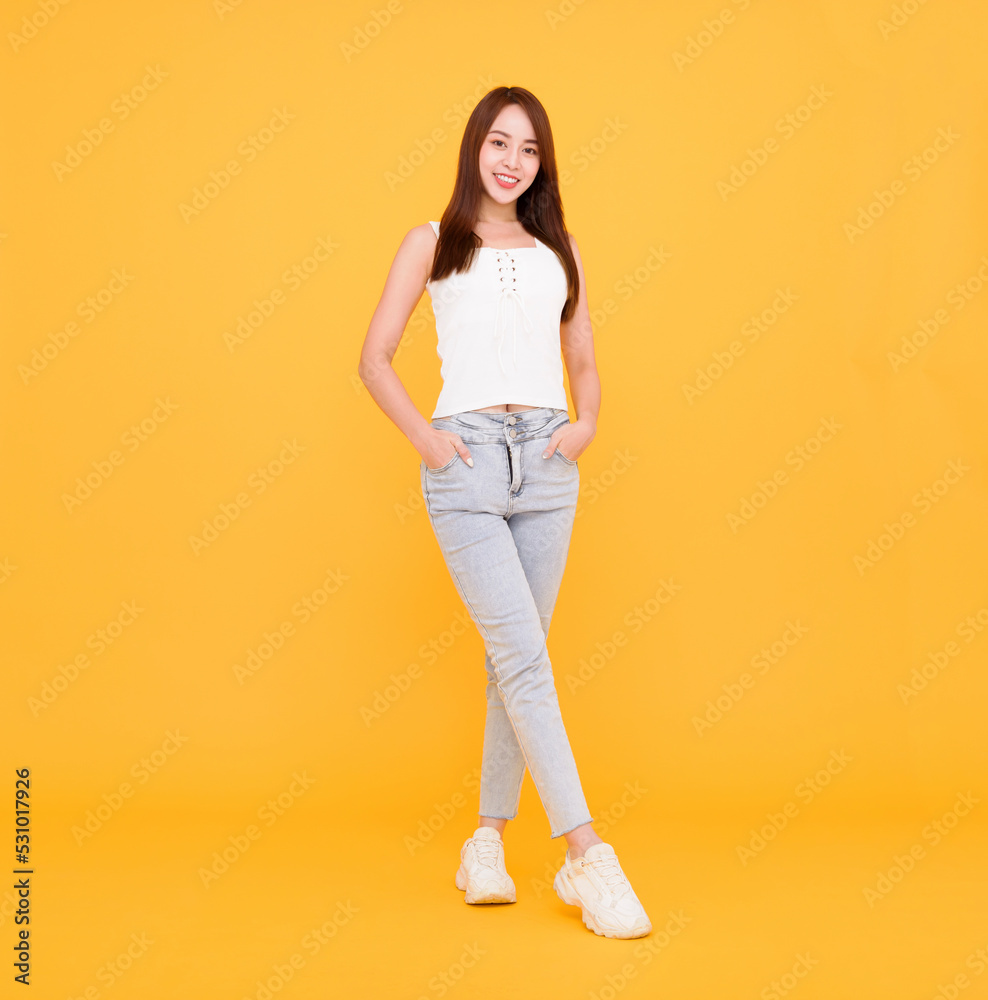 Full length of Happy young woman standing isolated over yellow Full length of Happy young woman standing isolated over yellow