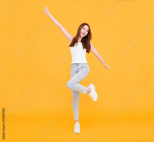 Happy Asian woman jumping and celebrating  isolated over yellow © Tom Wang