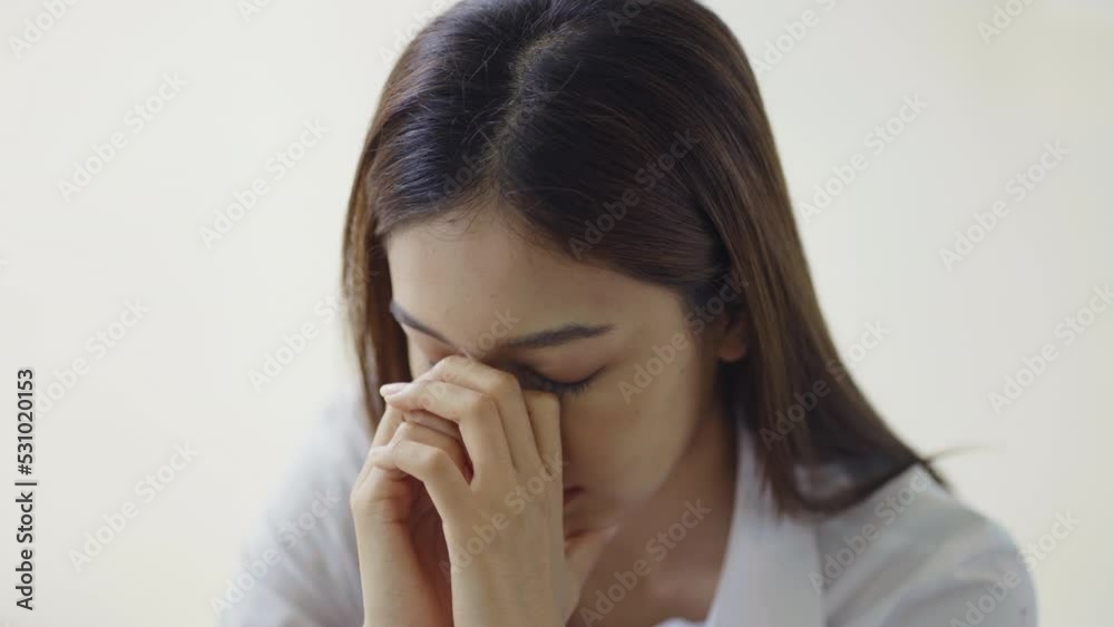 Tired Thai student girl at university in office holding his head on hands feel headache. Asian woman feeling stress from work in the office. Tired Thai student girl at university in office holding his head on hands feel headache. Asian woman feeling stress from work in the office.