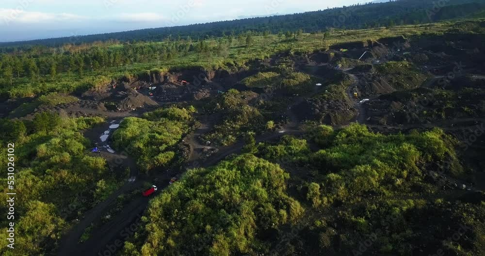 Aerial flyover LARGE SAND MINE ON THE SLOPE OF MERAPI VOLCANO WITH TRUCK ACTIVITY ON IT Aerial flyover LARGE SAND MINE ON THE SLOPE OF MERAPI VOLCANO WITH TRUCK ACTIVITY ON IT