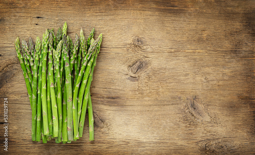 Bunch of green asparagus on wooden background. Copy space
