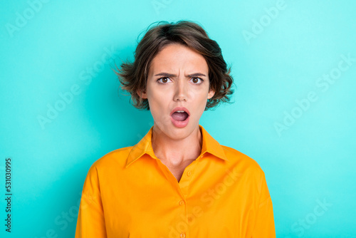Portrait of astonished unhappy upset girl with bob hairstyle dressed yellow blouse blaming look isolated on turquoise color background