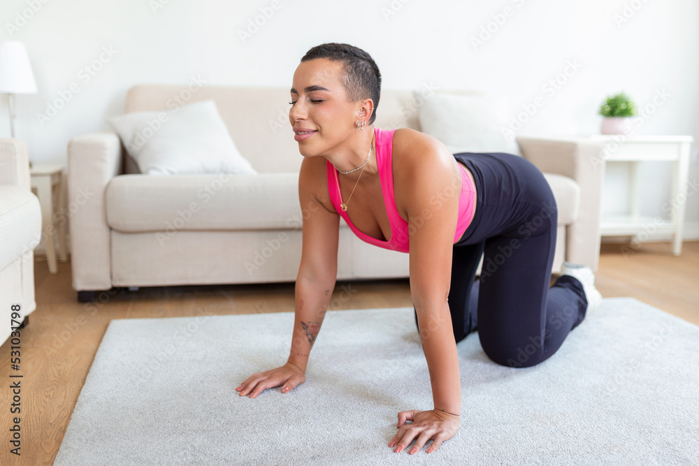 Fototapeta premium Warming Up Before Workout. Smiling Sporty Black Woman Training At Home Or Fitness Club Studio, Beautiful Female Stretching Legs After Exercises On Mat