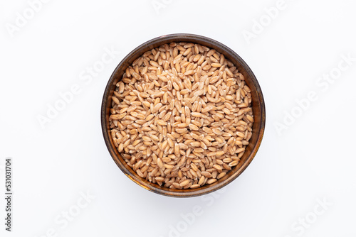 Wheat grains and wooden bowl on white background.