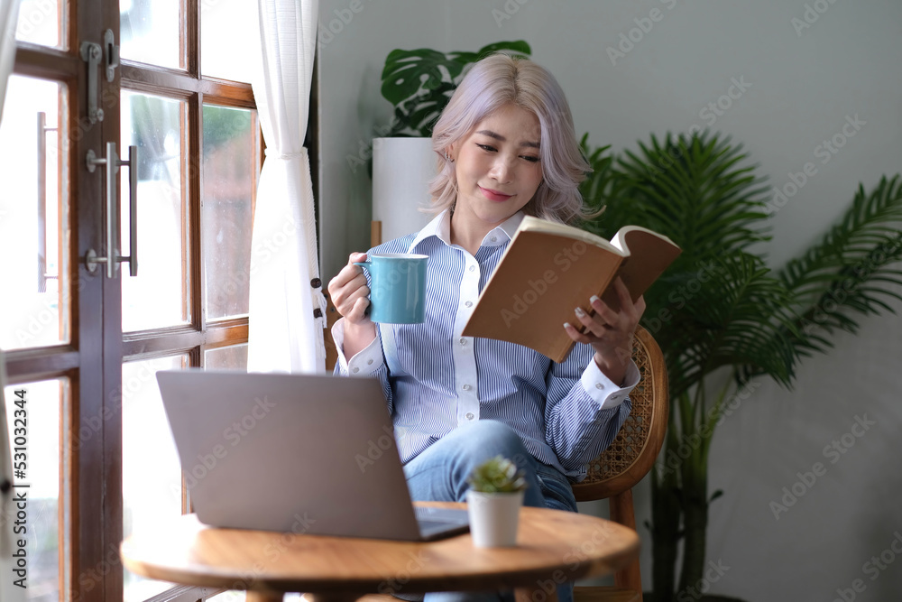 Portrait Asian woman reading book and relaxing with coffee at home Portrait Asian woman reading book and relaxing with coffee at home