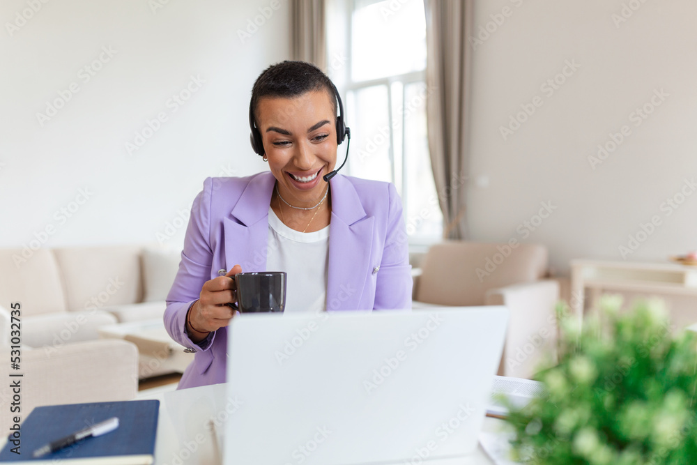 Happy young woman working on laptop while talking to customer on phone. Consulting corporate client in conversation with customer using computer. Service desk consultant talking in a call center. Happy young woman working on laptop while talking to customer on phone. Consulting corporate client in conversation with customer using computer. Service desk consultant talking in a call center.