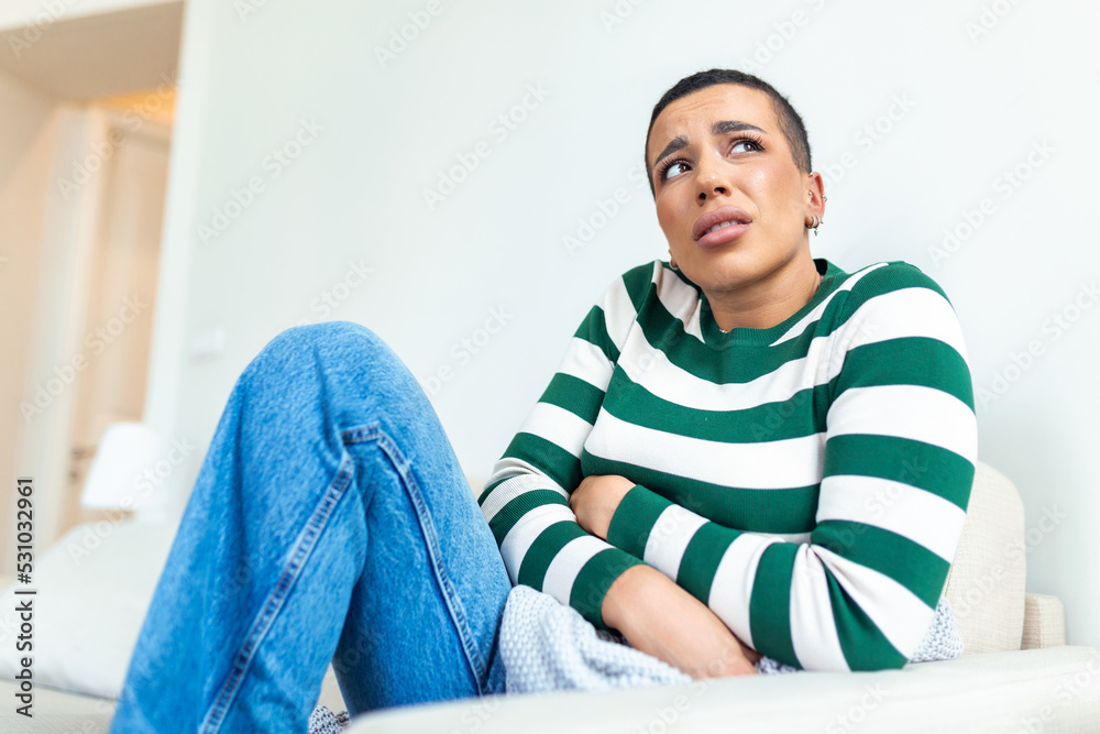 African American Woman in painful expression holding hands against belly suffering menstrual period pain, lying sad on home bed, having tummy cramp in female health concept African American Woman in painful expression holding hands against belly suffering menstrual period pain, lying sad on home bed, having tummy cramp in female health concept
