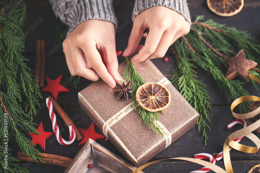 Woman hands making Christmas day gifts.