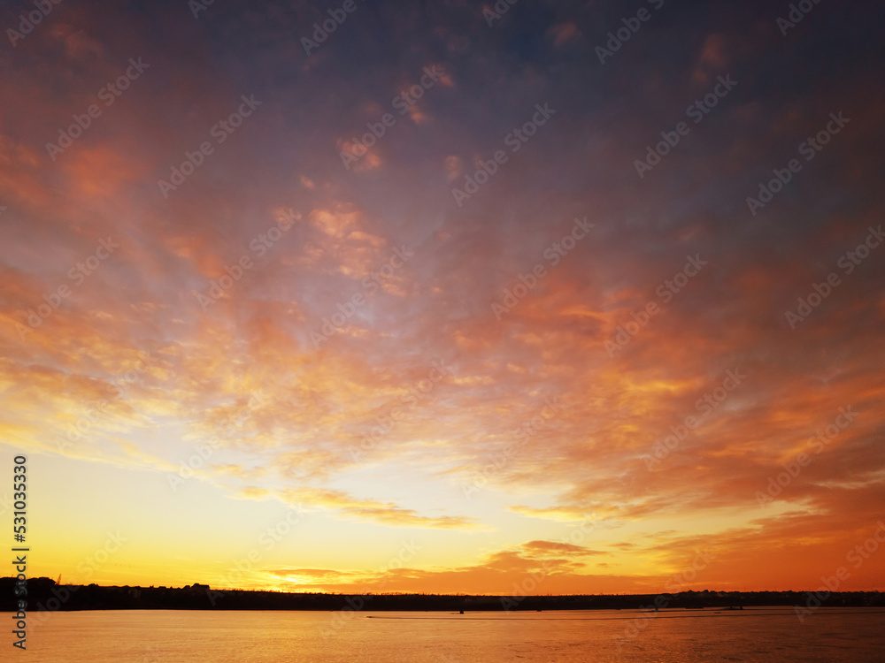 Sunset on the shore of the lake with red clouds