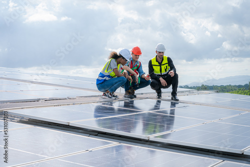 Engineers checking the operation of the system solar cell on an building in an residential area,Photovoltaic module idea for clean energy production.