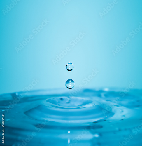 Falling drops of pure blue water in macro