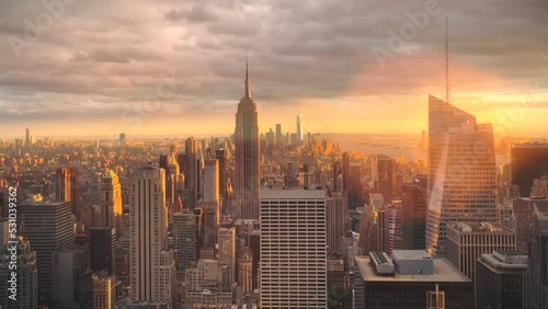Manhattan skyscraper in New York City at dusk as the sun is setting behind the urban cityscape 
