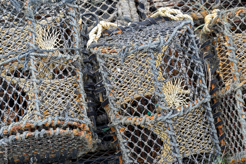 Close up view of lobster pots on the side of a harbour. No people.