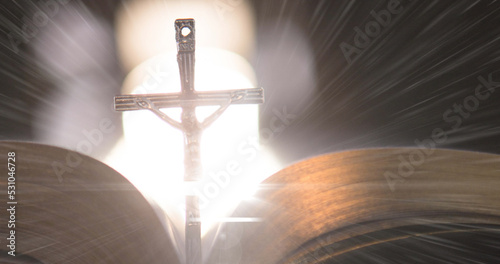 Image of christian cross with bible on glowing background