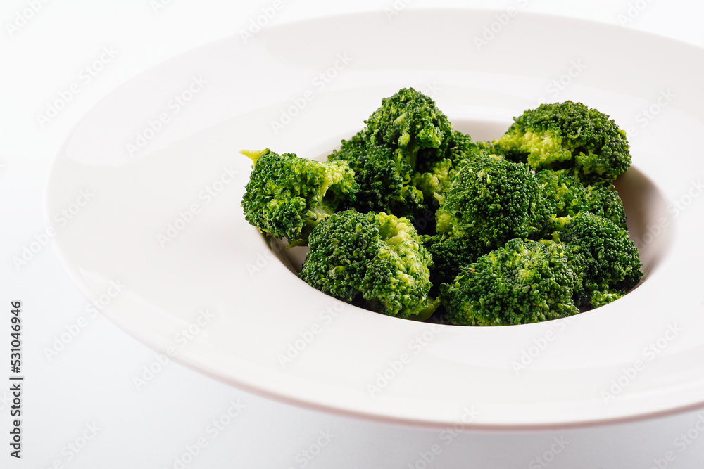 Fresh green broccoli in white circle plate isolated on white Fresh green broccoli in white circle plate isolated on white