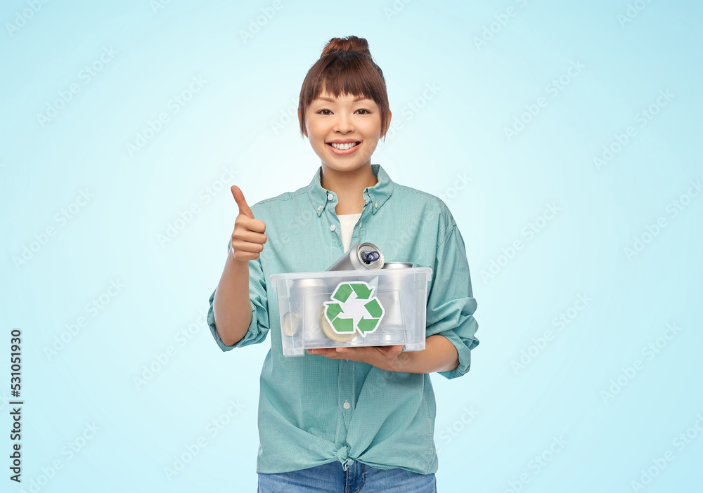 metal recycling, waste sorting and sustainability concept - smiling young asian woman holding plastic box with tin cans showing thumbs up over blue background metal recycling, waste sorting and sustainability concept - smiling young asian woman holding plastic box with tin cans showing thumbs up over blue background