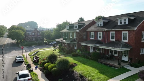 Beautiful view of small town houses during foggy morning sunrise. Slow aerial turning shot. photo