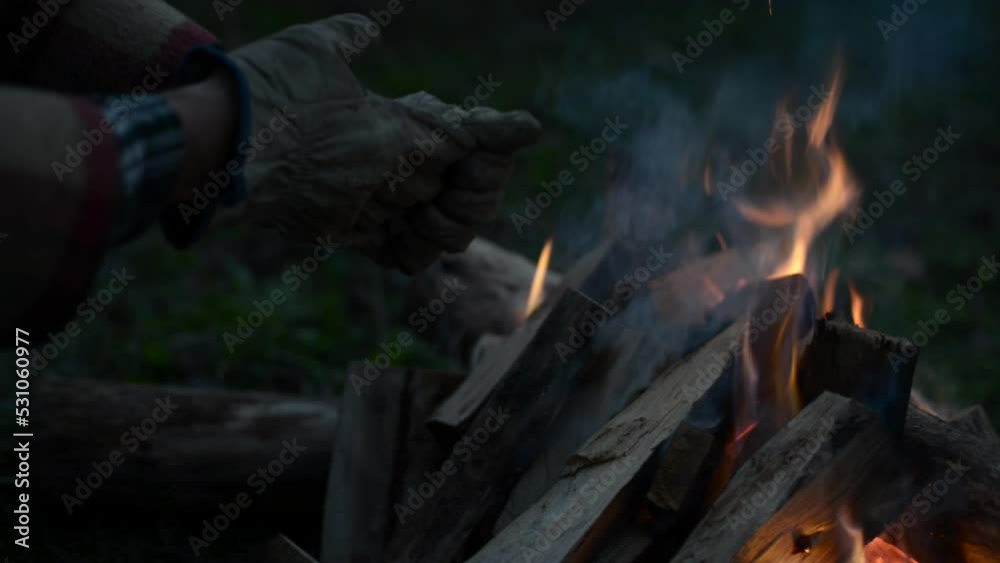 Side view from a man warming his hands by the fire Side view from a man warming his hands by the fire