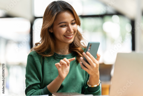 Asian businesswoman in formal suit in office happy and cheerful during using smartphone and working. Free Download Asian businesswoman in formal suit in office happy and cheerful during using smartphone and working. - GFXLoad