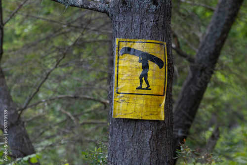 An old weathered yellow marker sign indicating a place for portaging route, blurred thick forest in the background. Camping, kayaking, canoeing, trip, adventure, active lifestyle concept. photo