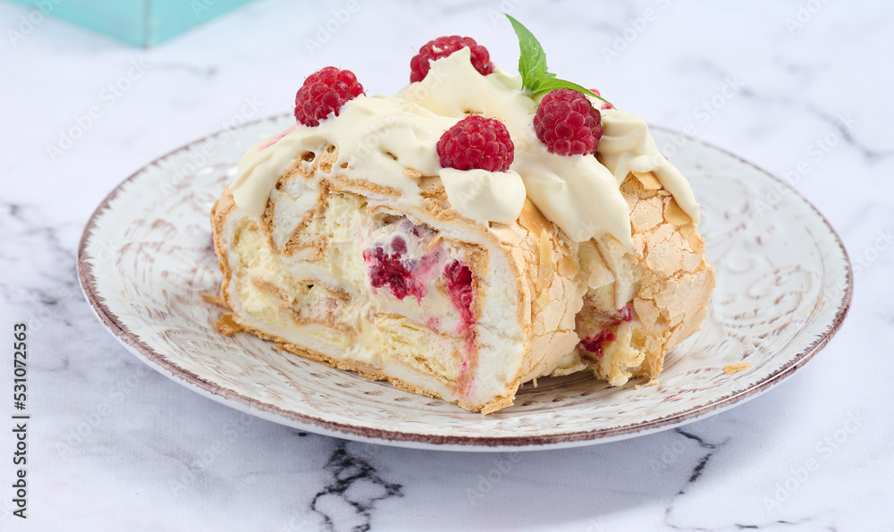 Baked meringue roll with cream and fresh red raspberry, white background. Baked meringue roll with cream and fresh red raspberry, white background.