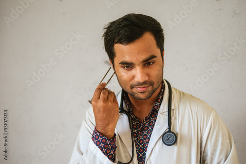 South asian doctor with a tuning fork in hand. Bangladeshi medical student with neurological diagnostic tool. photo