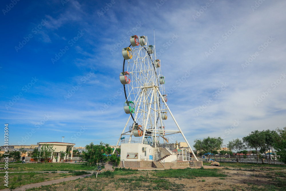 View to the Public Amusement Park with Ferris Wheel and White Rotunda in Urgench, Uzbekistan View to the Public Amusement Park with Ferris Wheel and White Rotunda in Urgench, Uzbekistan