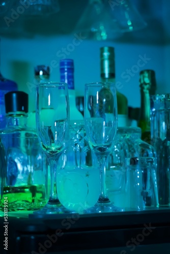 Vertical shot of glasses and bottles on the bar table photo