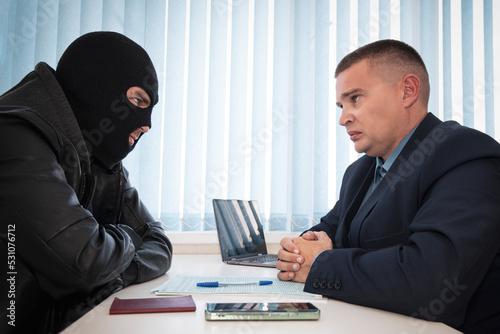 Fototapeta businessman and robbers are sitting at a table
