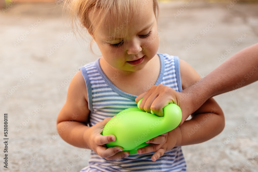 Little gir playing with anti stress sensory ball squeeze toy. Giant stress balls are soft to the touch and help reduce stress and anxiety as you pull, squish, smash, sensory toy Little gir playing with anti stress sensory ball squeeze toy. Giant stress balls are soft to the touch and help reduce stress and anxiety as you pull, squish, smash, sensory toy