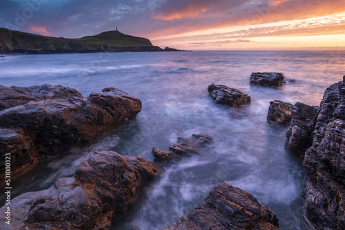 Sunset over Cape Cornwall from the rocky shores of Porth Ledden, Cornwall, England photo