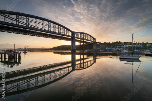 Sunrise over the Royal Albert Bridge which spans the River Tamar in Saltash, Cornwall, England photo