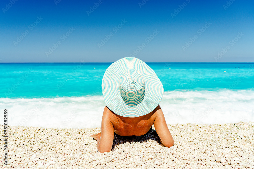 © robertharding - Carefree woman with straw hat sunbathing lying on a idyllic beach, Kefalonia, Ionian Islands, Greek Islands, Greece © robertharding - Carefree woman with straw hat sunbathing lying on a idyllic beach, Kefalonia, Ionian Islands, Greek Islands, Greece