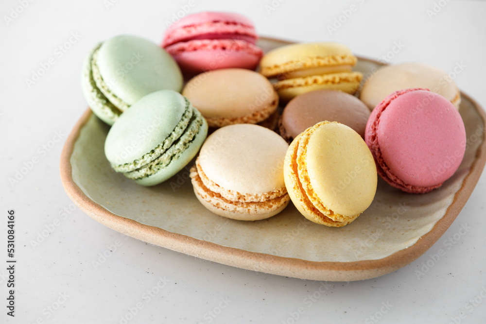 Various colorful macaroons on a plate on a white table, Various colorful macaroons on a plate on a white table,