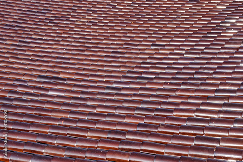 Close-up to texture of brown tile on the roof.