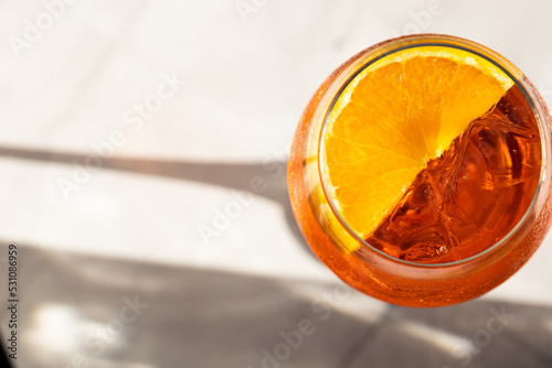 close up of aperol spritz cocktail with orange slice and ice