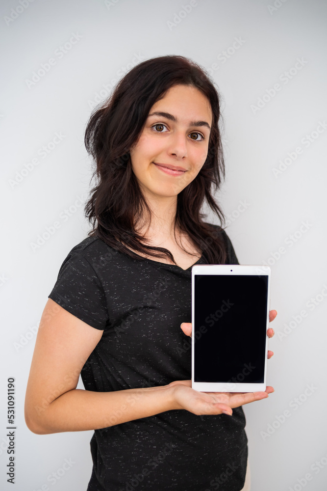 Pretty teenager girl holds tablet. Mock up with schoolgirl and black screen Pretty teenager girl holds tablet. Mock up with schoolgirl and black screen